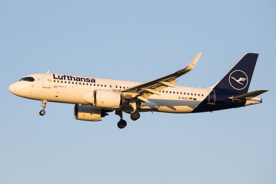 Vienna, Austria - 30 April, 2023: Lufthansa Airbus A320 airplane in the air with beautiful sunset light and blue sky