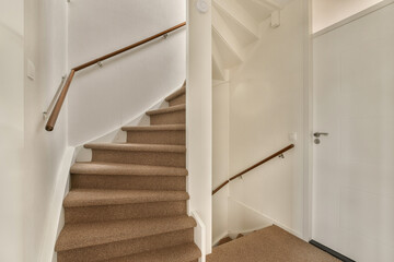 a stairway way in a house with carpet on the floor and stairs leading up to the second floor, there is an open door