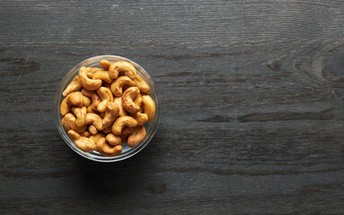 Cashew nuts in bowl on a wood