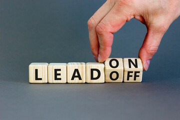 Lead on or off symbol. Businessman turns wooden cubes and changes word Lead off to Lead on....