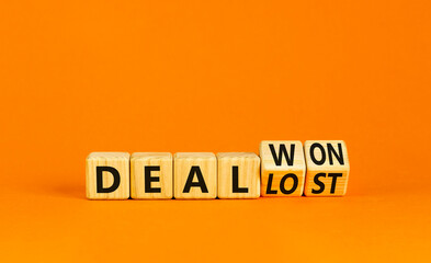 Deal lost or won symbol. Businessman turns wooden cubes and changes words Deal lost to Deal won. Beautiful orange table orange background, copy space. Business and deal lost or won concept.