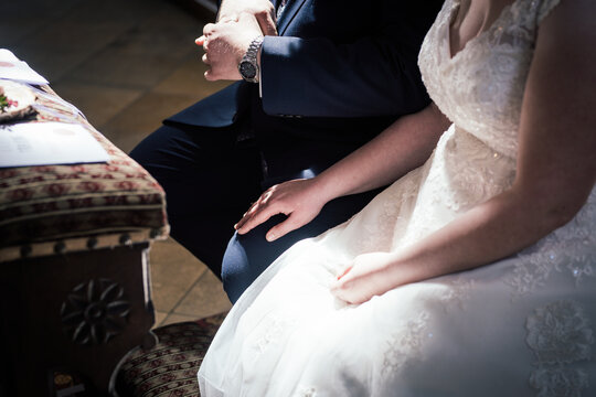 Braut legt die Hand auf das Bein des Bräutigam bei der Trauung