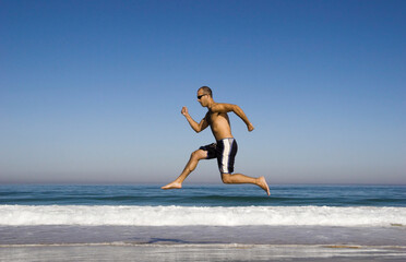 Fototapeta na wymiar Man running and jumping on the beach