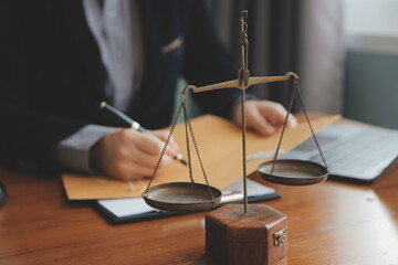 Business and lawyers discussing contract papers with brass scale on desk in office. Law, legal...