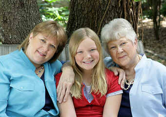 Fototapeta premium Three generations - a little girl, her mother, and her grandmother. All with blond hair and blue eyes.