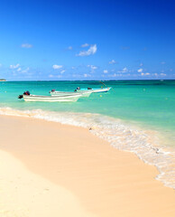 Fototapeta na wymiar Fishing boats in Caribbean sea anchored near sandy beach