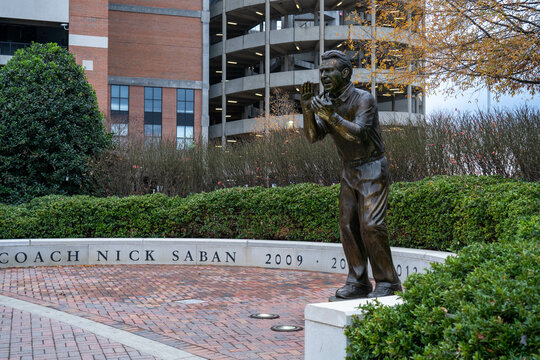 A Statue Of National Championship Winning Football Coach Nick Saban Outside Of Bryant-Denny Stadium On The Campus Of The University Of Alabama On An Overcast Day.