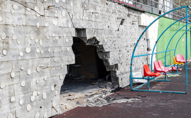 War in Ukraine. Broken plastic benches for fans on the podium, in a destroyed football stadium in a children's football school. The consequences of shelling from artillery.