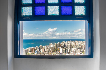 Photo of the buildings in the city of Vila Velha seen through the window of the Penha Convent.