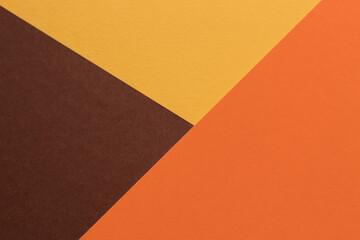 Orange and brown paper lies on the table, creating a geometric composition