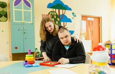 a psychologist is engaged with an adult autistic man in the office