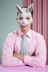 Businessman with funny rabbit mask portrait over wallpaper