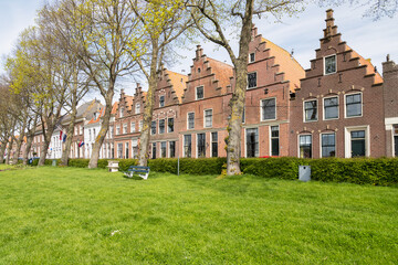 Fototapeta na wymiar Historic houses with stepped gables along the harbor in Medemblik in West Friesland.