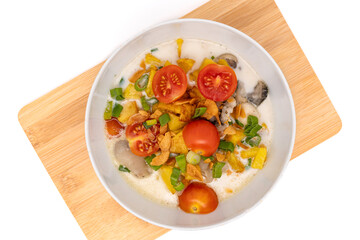 Top view of sop kaki kambing or mutton soup, a traditional food from Betawi-Jakarta, Indonesia. Made from mutton or lamb, spices, coconut milk, and milk. Isolated on white background with copy space.