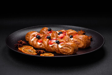 Delicious fresh crispy pastry in the form of a pigtail with strawberries and blueberries