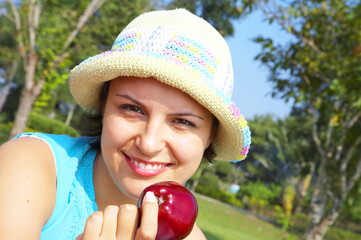 Portrait of young beautiful woman in colorful hat in summer environment