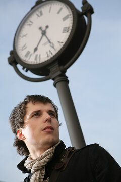 Young man near the street clock.