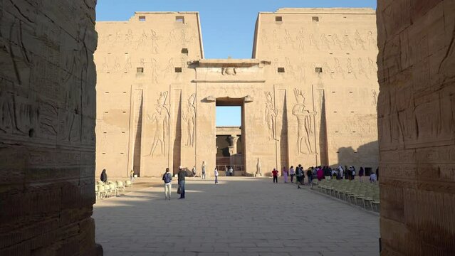 EDFU EGYPT. DECEMBER 2022. DOLLY IN Panoramic view of the entrance of the Temple of Edfu. This temple is dedicated to the falcon god Horus On the walls of the temple there are different carved reliefs