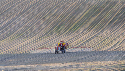 Stary traktor pracujący w polu. Opryskiwanie upraw wiosną na Lubelszczyźnie w Europie. - obrazy, fototapety, plakaty