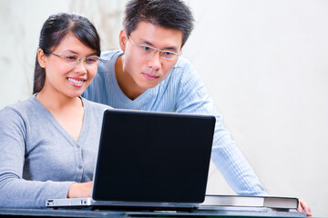 Young Asian couple browsing internet at home