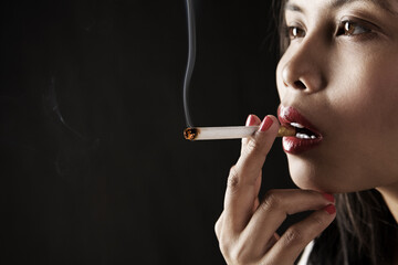 Obraz premium Woman smoking on dark area