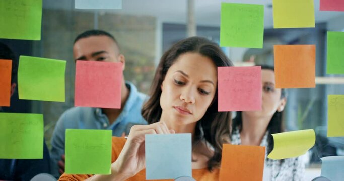 Leadership, thinking or woman writing on sticky notes planning vision, mission or goal for KPI growth in meeting. Diversity, teamwork or startup people for strategy in marketing schedule or calendar