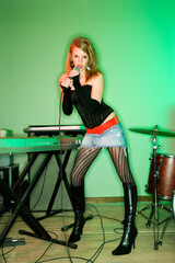 Caucasian female singing into microphone.