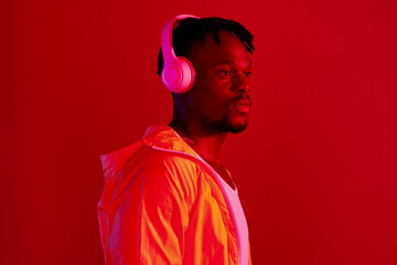 Headphones, fashion and black man profile with music and online song streaming. Internet radio, web audio and African male model with red background in a studio with gen z style and neon lighting