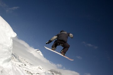 Naklejka na ściany i meble snowboarder jumping high in the air