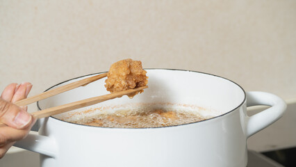 鶏の唐揚げ・調理シーン｜揚がった唐揚げを油から取り出す