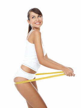 Young beautiful woman with measure tape on white
