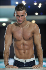 Fototapeta na wymiar young healthy good looking macho man model athlete at hotel indoor pool