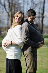 Fototapeta premium happy young married family couple outdoor in nature have fun and waiting baby and representing young family growth and pregnancy concept