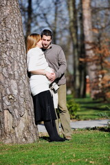 Fototapeta premium happy young married family couple outdoor in nature have fun and waiting baby and representing young family growth and pregnancy concept