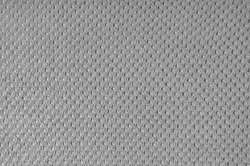 Close up background of knitted wool fabric with dots pattern. Gray color wool knitwear texture. Openwork abstract knitted jersey. Fabric abstract backdrop