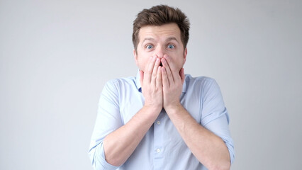 The European young man, in shock, covers his mouth with his hands, thinking, No, this is impossible.