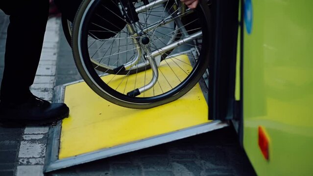 Person with a physical disability enters public transport with an accessible ramp