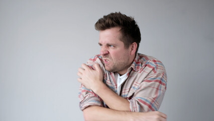 The European young man nervously scratches his hands. He has an allergy, and the itching bothers him
