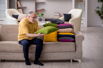 Old man with many pillows at home