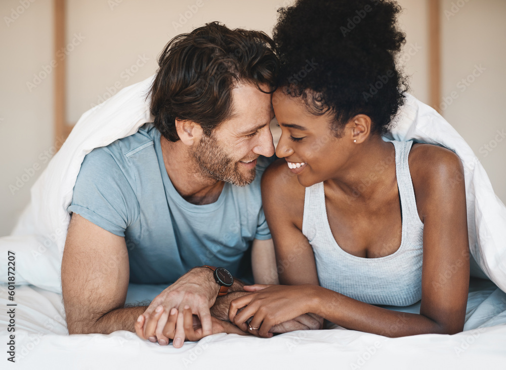 Sticker Happy interracial couple, bed and intimate morning in relax or bonding relationship at home. Man and woman smiling in joyful happiness for love, affection or relaxing weekend together in the bedroom