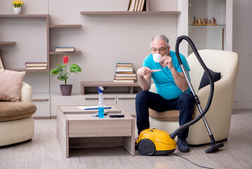 Old male contractor cleaning the house