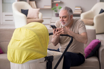 Old man looking after newborn at home