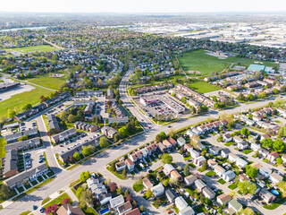 Drone view, sun-drenched Brampton real estate, lush green yards, picturesque houses off Bramalea-Mayfield. Summer in Ontario at its best