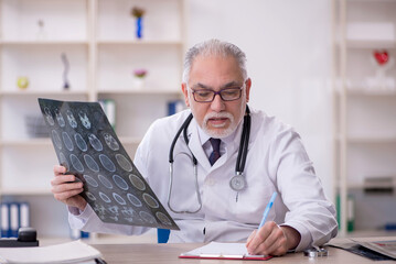 Old male doctor radiologist working in the clinic