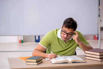 Young male student preparing for exams in the classroom