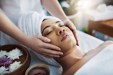 Woman, hands and face massage for skincare, relax or beauty spa treatment on bed at resort. Calm...