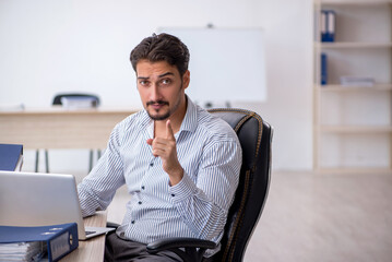 Young male employee and too much work in the office