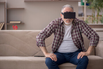 Old man wearing virtual glasses at home