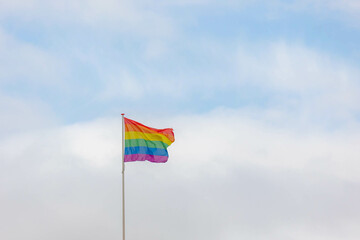 Celebration of pride month, Colourful rainbow flag hanging waving in the air with blue sky as background, Symbol of Gay, Lesbian, Bisexual and Transgender, LGBTQ community, Worldwide social movements.