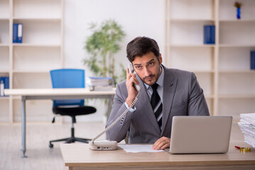 Fototapeta premium Young male employee and too much work in the office